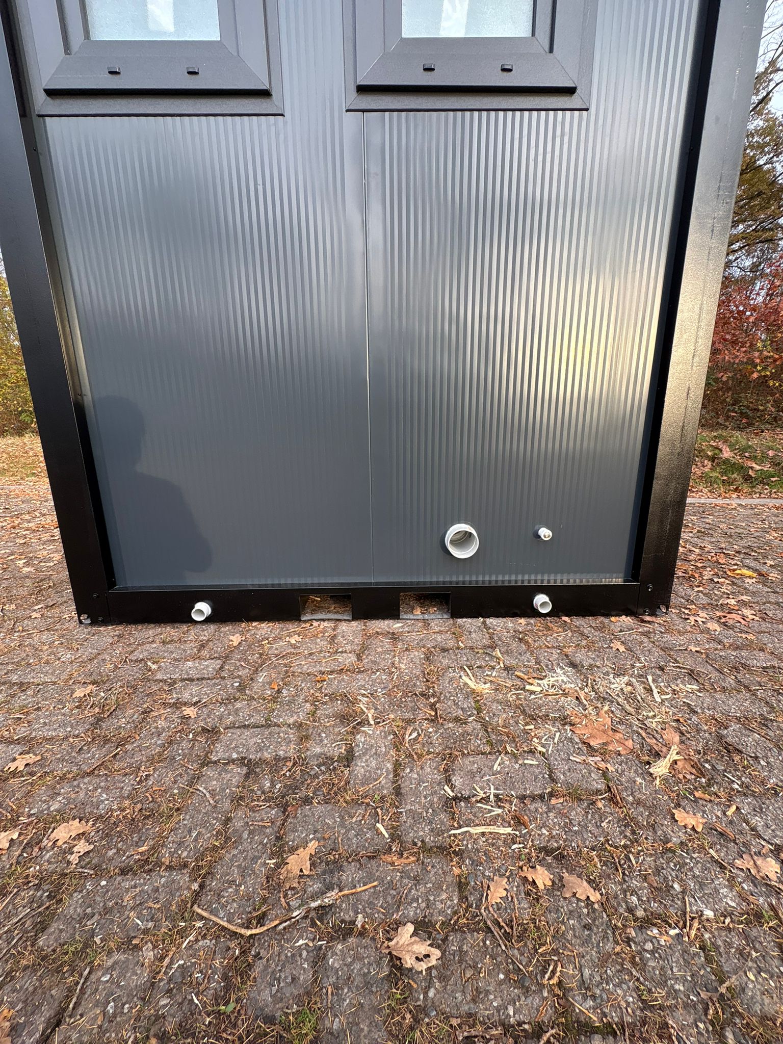 Aansluitingen aan de achterzijde van een toilet- en doucheunit.