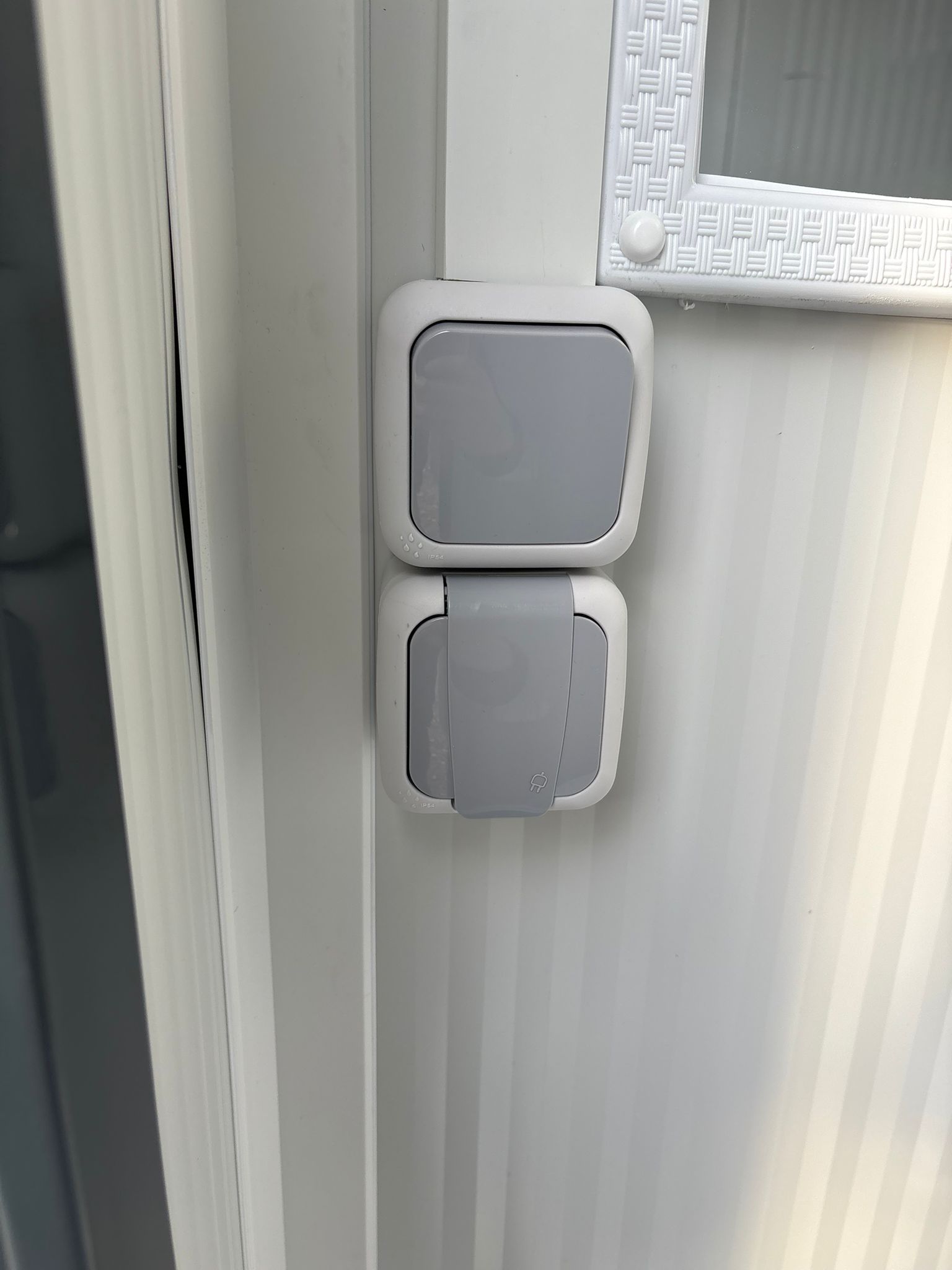 Lichtschakelaar en wandcontactdoos van een toilet- en doucheunit.