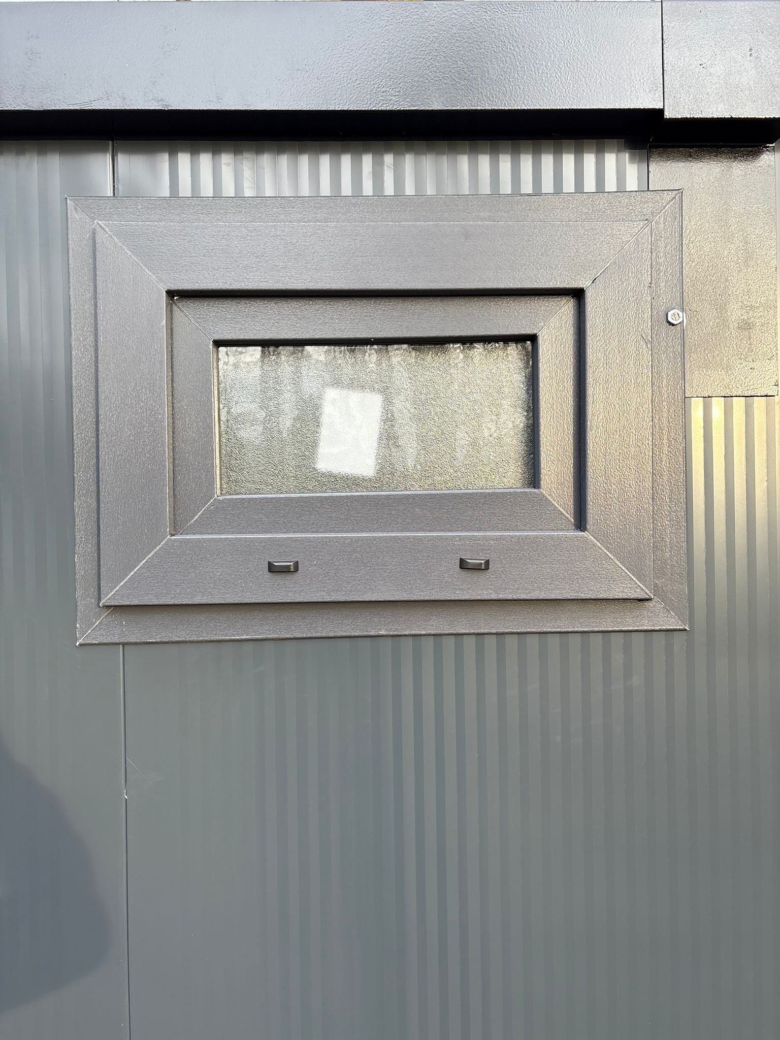 Raam aan de buitenzijde van een toilet- en doucheunit.