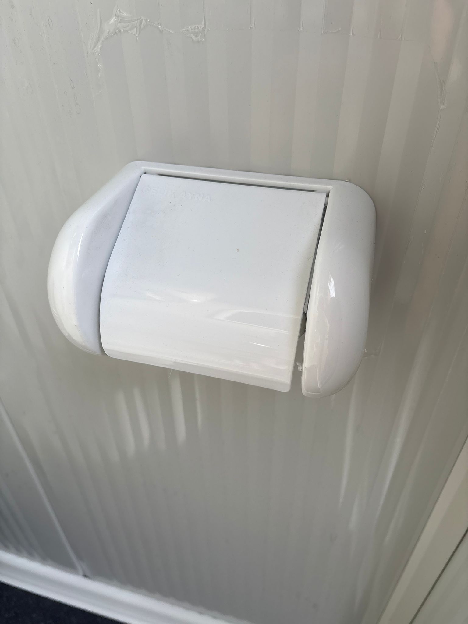 Toiletrolhouder in een toilet- en doucheunit.