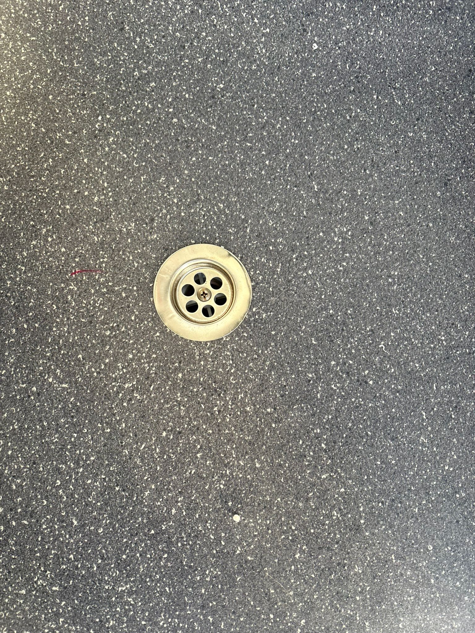 Vloerput in de toiletruimte van een toilet- en doucheunit.