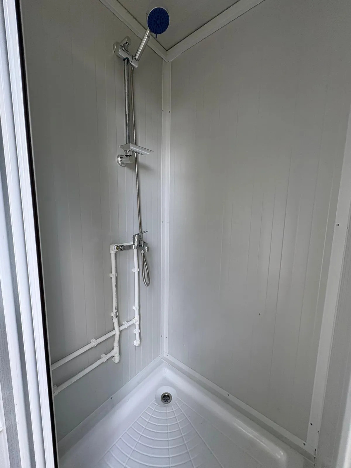 Interior of a portable bathroom unit showing shower set