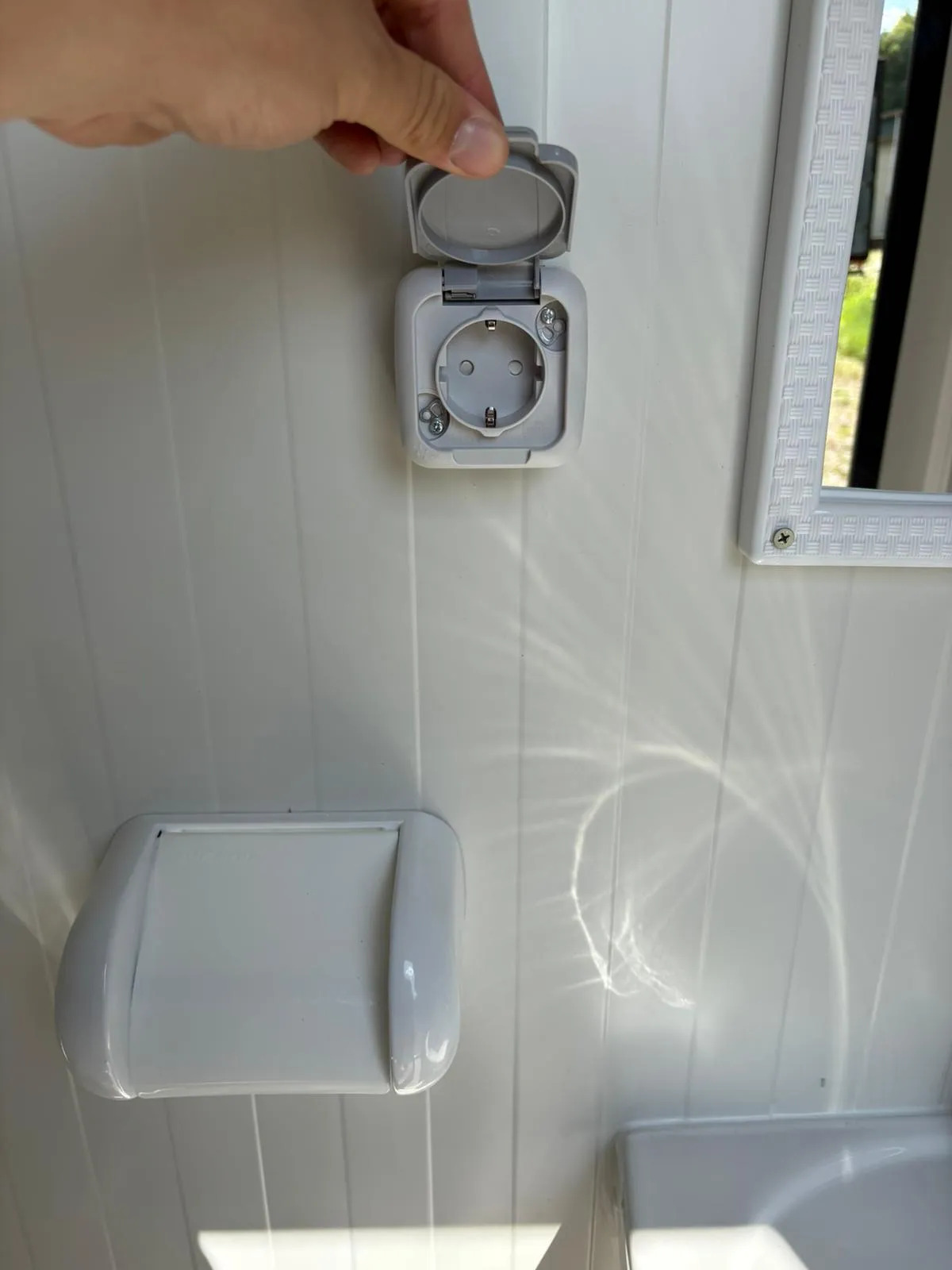 Electrical socket inside a portable bathroom unit