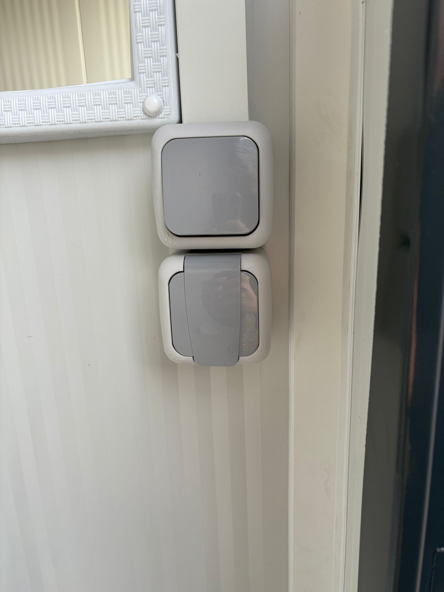 Lichtschakelaar aan de rechterzijde van een dubbele toiletunit.