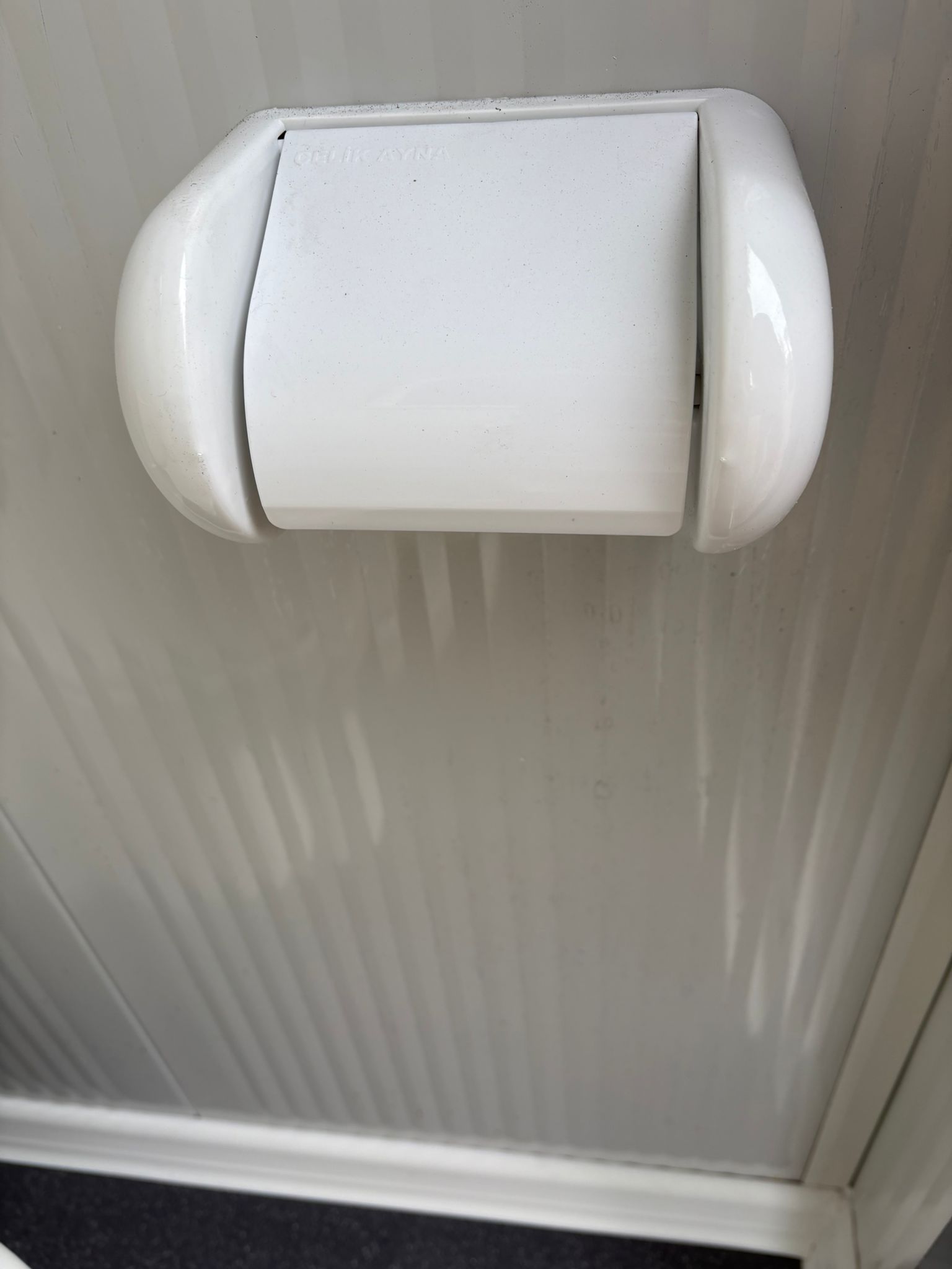 Toiletrolhouder in een dubbele toiletunit.