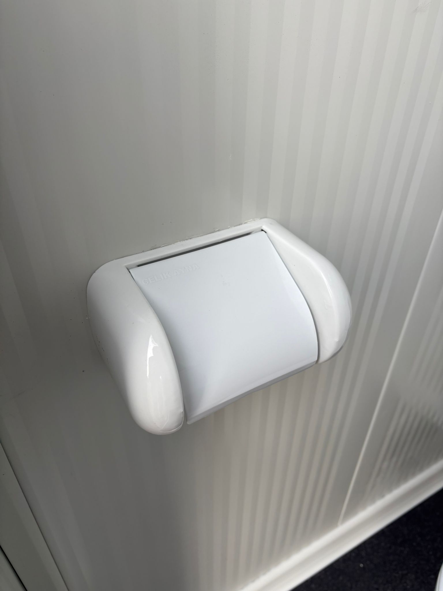 Toiletrolhouder aan de rechterzijde van een dubbele toiletunit.