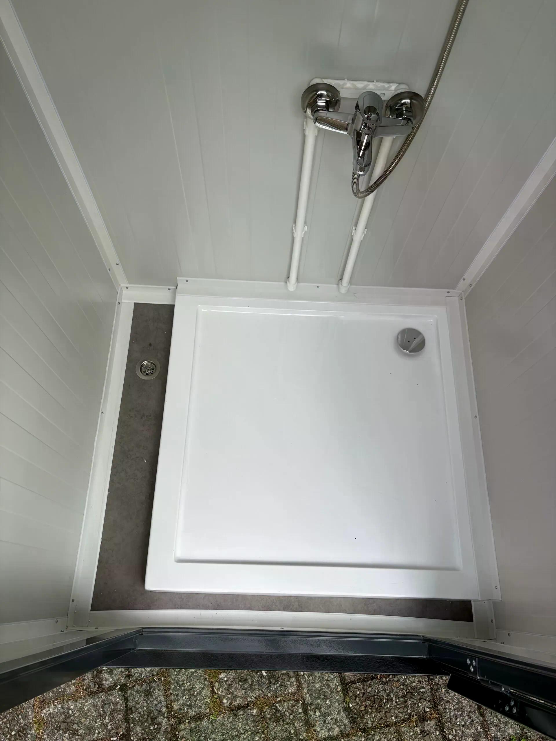 Floor of a dual portable shower unit with non-slip surface