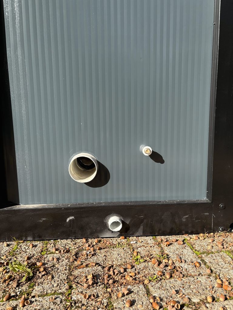 Front view of sewer and water connections on a portable toilet unit for camping