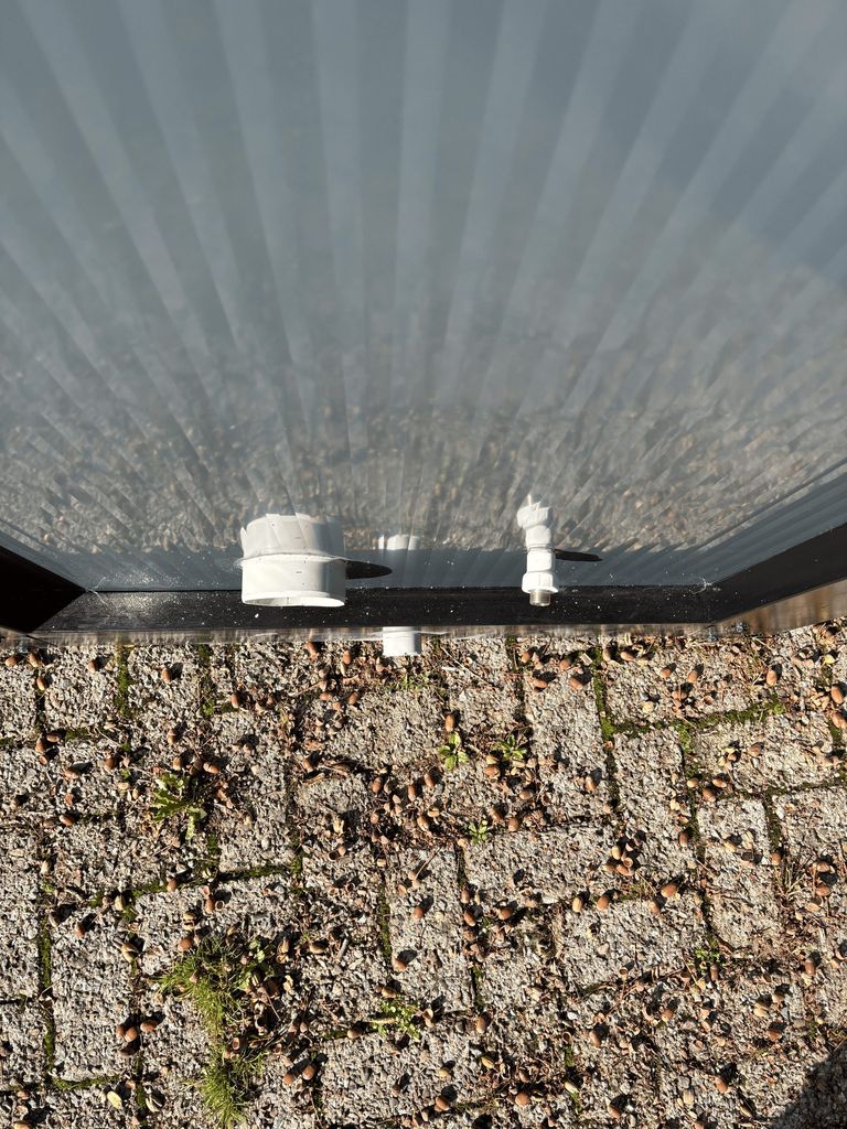 Top view of sewer and water connections on a portable toilet unit for camping