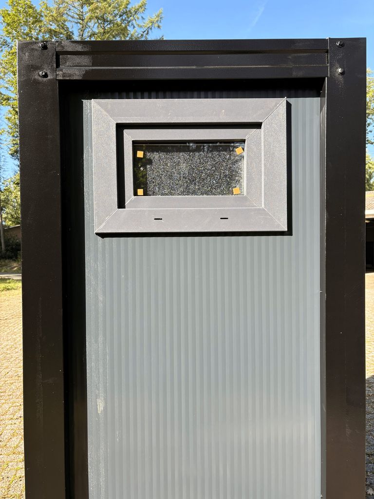 Exterior view of a portable toilet unit for camping with closed window
