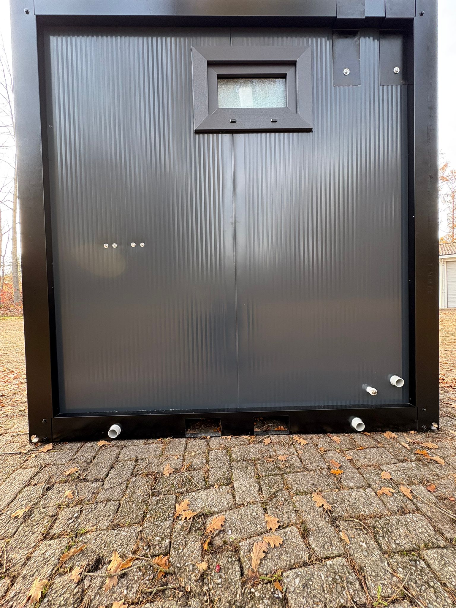 Achterzijde van een doucheunit met omkleedruimte.