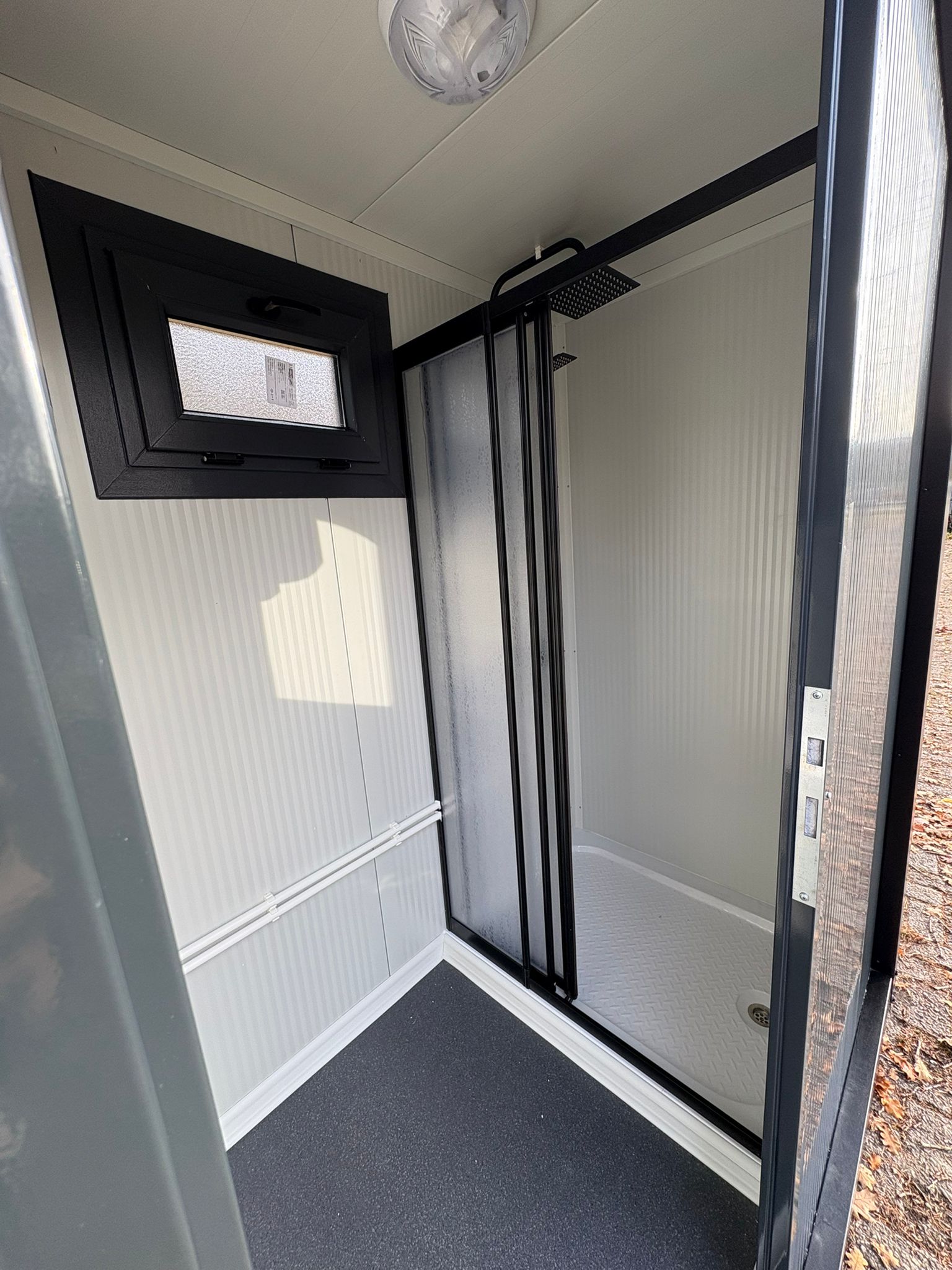 Deur van een doucheunit met omkleedruimte.