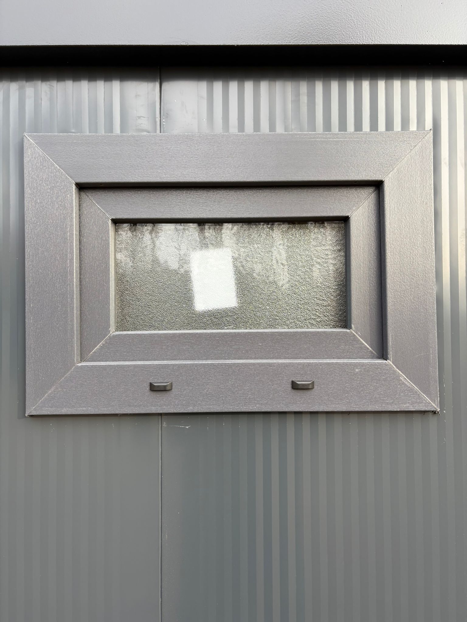 Buitenzijde van het draaikiepraam van een doucheunit met omkleedruimte.