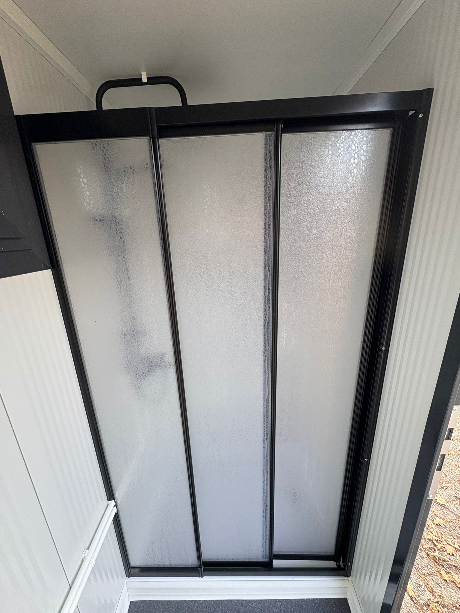 Glazen douchewand van een doucheunit met omkleedruimte.