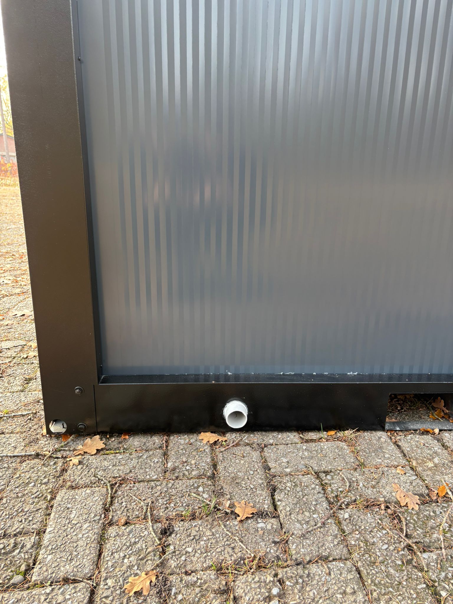 Vloerput en afvoer van een doucheunit met omkleedruimte.